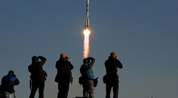 Krievijas kosmosa kuģa startu ar olimpisko lāpu fiksē fotogrāfi. Foto: AFP/LETA