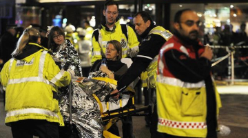 Glābēji sniedz palīdzību "Apollo" teātra jumta iebrukumā cietušajai. Foto: LETA/EPA