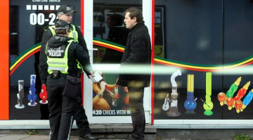 Policijas darbinieki pie "legālo narkotiku" tirgotavas Marijas ielā. Foto: Edijs Pālens, LETA