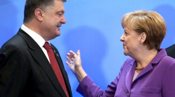 Vācijas kanclere Angela Merkele sveic Ukrainas prezidentu Petro Porošenko ar asociācijas līguma parakstīšanu. Foto: AFP/LETA