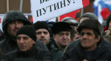 Tauta Maskavas Sarkanā laukumā, "svinot" Krimas aneksiju. Plakāts vēsta: "Ticam Putinam!" Foto: EPA/LETA