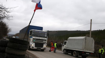 Uz robežas - iebraukšanu Sevastopolē stingri kontrolē prokrieviskie spēki. Par to liecina Krievijas karogs kontrolpunktā. Foto: ITAR-TASS/LETA