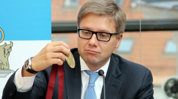 Rīgas mērs Nils Ušakovs pēta 'Nordea maratona' medaļu. Foto: Sintija Zandersone, LETA