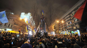 Protestētāji Ļeņina pieminekļa vietā uzvilkuši Ukrainas karogu. Foto: AFP/LETA