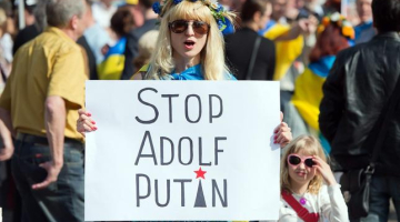 Ukrainas neatkarību atbalstoša demonstrante Vācijas pilsētā Frankfurtē pie Mainas rokās tur plakātu ar uzrakstu: "Stop Adolf Putin". Foto: EPA/LETA