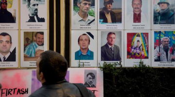 Ukrainas protestos bojāgājušo fotogrāfijas novietotas arī Londonā, godinot viņu piemiņu. Foto: AFP/LETA