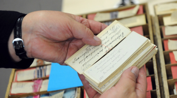 Dainu skapja atvilknes ar latviešu folklorista Krišjāņa Barona savāktajām latviešu tautasdziesmu kartēm Latvijas Nacionālo bibliotēkas ēkā "Gaismas pils". Foto: Ieva Lūka, LETA