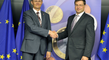 Finanšu ministrs Andris Vilks (no kreisās) un valdības vadītājs Valdis Dombrovskis pozē Briselē pēc paziņojuma par eiro ieviešanu Latvijā. Foto: AFP/LETA