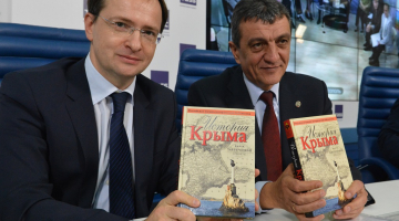 Krievijas kultūras ministrs Vladimirs Medinskis (no kreisās) un okupētās Sevastopoles gubernators Sergejs Meņailo ar pārrakstīto Krimas vēstures grāmatu. Foto: ITAR-TASS/LETA