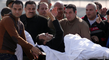 Bijušais Ēģiptes prezidents Hosni Mubaraks nestuvēs sveicina sagaidītājus. Foto: AFP/LETA