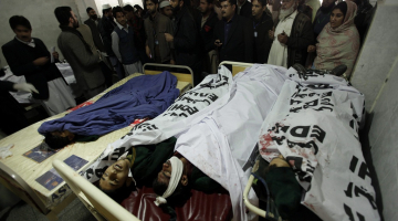 Vecāki un glābēji pie islāmistu uzbrukumā skolai Pakistānā nogalināto jauniešu mirstīgajām atliekām. Foto: EPA/LETA