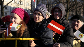 Cilvēki valsts svētku parādē Daugavmalā. Foto: Evija Trifanova, LETA