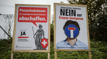 Šveices referenduma plakāti - viens saka 'nē' "Ecopop" iniciatīvai, otrs - 'jā'. Foto: AFP/LETA