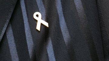 Starptautiskās labdarības kustības, kuras mērķis ir solidarizēt un atbalstīt krūts vēža pacientus un viņu ģimenes visā pasaulē, piespraude "Pink Ribbon" ("rozā lentīte"). Foto: Ieva Čīka, LETA