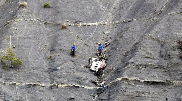 Franču glābšanas dienesta darbinieki pie Germanwings pasažieru lidmašīnas atlūzām Alpu nogāzē.