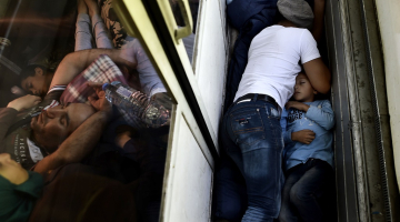 Sīrijas bēgļi guļ vilcienā ceļā no Maķedonijas. Foto: AFP/LETA