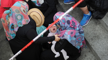 Sīriešu patvēruma meklētājas ar bērnu Vācijas pilsētas Rozenheimas dzelzceļa stacijā. Foto: AFP/LETA