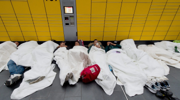 Sīrijas, Irākas un Pakistānas bēgļi un patvēruma meklētāji guļ uz grīdas Frankfurtes centrālajā dzelzceļa stacijā. Foto: AFP/LETA