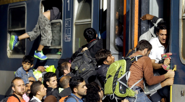 Sīriešu bēgļi laužas vilcienā, kam jādodas uz Austriju, Budapeštas dzelzceļa stacijā. Foto: AFP/LETA