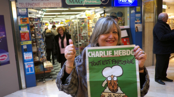 Sieviete Marseļā priecājas, ka dabūjusi "Charlie Hebdo" jaunāko numuru. Foto: AFP/LETA