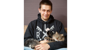 Niklāvs Sekačs ar Pici — viņai par godu mugursoma apdrukāta ar kaķīšu galvām.