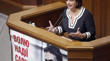 Ukrainas finanšu ministre Natālija Jaresko uzstājas parlamentā. Tribīnei piestiprināts plakāts, kas aicina atbrīvot Ukrainas lidotāju Nadeždu Savčenko. Foto: AFP/LETA