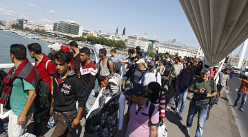 Migranti Budapeštā pāri Donavas tiltam dodas Austrijas virzienā. Foto: AFP/LETA