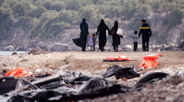 Migrantu ģimene Lesbos salā Grieķijā pēc ierašanās no Turcijas puses aiz sevis atstāj pamestas glābšanas vestes un dodas tālāk. Foto: AFP/LETA
