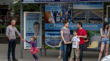 Pieturvieta Kišiņevā ar Liberālās partijas pārstāvja un nu jau vēlēšanu uzvarētāja Dorina Kirtoakes reklāmu. Foto: EPA/LETA