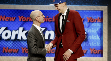 Latviešu basketbolists Kristaps Porziņģis (no labās) Nacionālās basketbola asociācijas (NBA) drafta ceremonijā pasniedz roku līgas komisāram Adamam Silveram. Foto: EPA/LETA