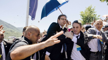 Serbijas premjerministrs Aleksandrs Vučičs (centrā) tiek apmētāts ar akmeņiem. Foto: AFP/LETA