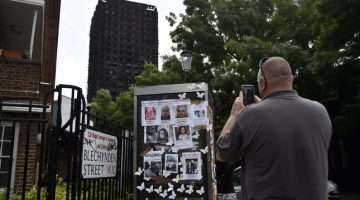 ''Grenfell Tower'' ugunsgrēkā pazudušo cilvēku fotogrāfijas pie nodegušās ēkas. Foto: Reuters-LETA