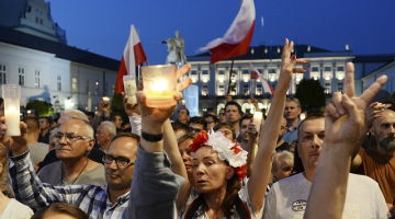 Protestētāji Polijā pie prezidenta pils izsaka neapmierinātību ar valdības iecerēto tieslietu reformu. Foto: AFP/LETA