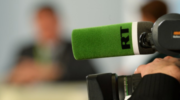 "Russia Today" logo uz mikrofona. Foto: Sputnik/LETA