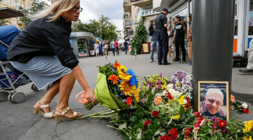 Cilvēki Kijevā liek ziedus vietā, kur tika nogalināts žurnālists Pāvels Šeremets. Foto: EPA/LETA