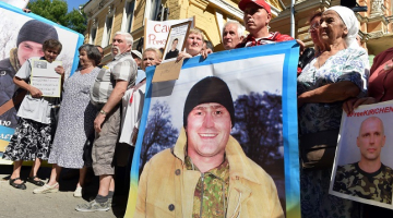 Ukrainas karavīru radinieki Kijevā pie prezidenta administrācijas ēkas ieradušies ar savu dēlu, kurus sagūstījuši prokrieviskie separātisti Donbasā, attēliem. Foto: AFP/LETA
