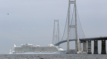 Svētdien bēguma laikā Somijā būvētajam pasažieru lainerim Allure of the Seas izdevās izspraukties zem tilta starp Kopenhāgenu un Malmi — atstarpe starp kuģa augstāko torni un tilta vēdera augstāko daļu bija tikai 51 cm. Foto — LETA/AFP