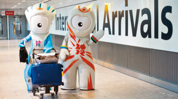 Londonas olimpisko spēļu talismani Venloks un Mendevils sagaida viesus Hītrovas lidostā. Tiek lēsts, ka nākamā mēneša laikā britu galvaspilsētu apmeklēs pusmiljons tūristu, neskaitot sportistus, trenerus un sporta funkcionārus. Savukārt 1,3 miljoni londoniešu izteikušies, ka centīsies pamest pilsētu, lai izbēgtu no sastrēgumiem un drūzmas.