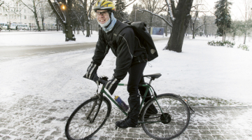 Rīgā jau vienpadsmit gadus pazīst dzelteno Reiņa Avena velokurjera ķiveri. Ziemā viņam nosalt neļauj draudzenes šūtie mokasīni un roku sildītāji. Foto — Rūta Kalmuka, F64