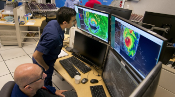 Vecākais viesuļvētru speciālists Liksions Avila (no kreisās) un Nacionālās okeānijas un atmosfēras pētījumu pārvaldes operatīvās nodaļas darbinieks Fils Manugjans seko radaram, kas rāda viesuļvētras "Irma" pārvietošanos.