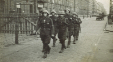 Attēlā redzamie puiši ir 22.latviešu policijas bataljona karavīri Varšavas ielās 1942.gadā. Kadrs no filmas Pretrunīgā vēsture