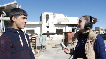 Kadrs no Radio Kobane. 20 gadus vecā Dilovana Kiko vada radio pārraides smagi izpostītajā  Sīrijas pilsētiņā Kobanē.