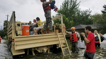Nacionālās gvardes karavīri palīdz Hjūstonas iedzīvotājiem evakuēties no plūdu skartajiem rajoniem. Foto: AFP/LETA
