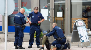 Turku policisti pie viena no sadurtajiem cilvēkiem. Foto: AFP/LETA