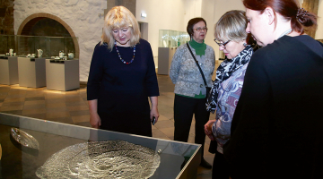 Izstādes apmeklētājas pie šķīvja Caurums ledū (1970). FOTO — leta un osmo thiel.iittala