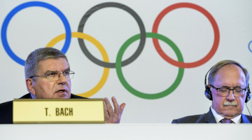 SOK prezidents Tomass Bahs (no kreisās) un SOK izmeklēšanas komisijas priekšsēdētājs Samuels Šmits preses konferencē paziņo SOK skarbo lēmumu par Krieviju. Foto: EPA/LETA