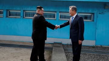 Dienvidkorejas prezidents Muns Džēins sarokojas ar Ziemeļkorejas līderi Kimu Čenunu uz abu valstu robežas. Foto: Reuters/LETA