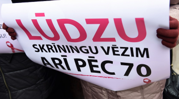 Pie Veselības ministrijas Rīgā seniores rīkoja zibakciju par vienlīdzīgu un taisnīgu valsts attieksmi pret senioriem, atceļot vecuma ierobežojumus bezmaksas vēža skrīniga saņemšanai. Foto: Ieva Leiniša, LETA