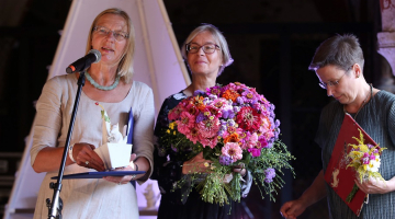 Jāņa Baltvilka balvu bērnu literatūrā saņem igauņu rakstniece Tīa Selli (centrā) par stāstu "Mia ir priecīga" un tulkotāja Maima Grīnberga (pa labi). Foto: Evija Trifanova, LETA