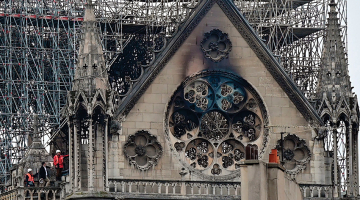 Nākamajā rītā pēc ugunsgrēka inspektori izvērtē postījumu apmēru.
Foto — AFP/LETA